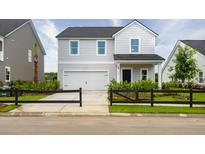Charming two-story home with a white garage door, black fence, and well-manicured landscaping at 600 Red Monarch Way, Moncks Corner, SC 29461