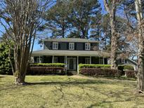 Charming two-story home featuring a welcoming front porch and beautifully landscaped yard with mature trees at 709 Chatter Rd, Mount Pleasant, SC 29464