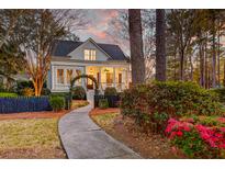 Charming two-story home with a inviting front porch and a beautifully landscaped front yard and lovely sidewalk at 724 Hibbens Grant Blvd, Mount Pleasant, SC 29464