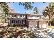 Charming two-story home with a spacious three-car garage and a inviting front porch, surrounded by lush landscaping at 8 Darien Dr, Charleston, SC 29414