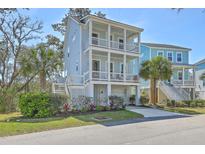 Charming three-story coastal home featuring double balconies, a lush yard, and a private garage at 824 Forrest Dr, Charleston, SC 29492