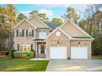 Lovely brick home with mature landscaping, two-car garage, and inviting front entrance at 8716 Dover Creek St, North Charleston, SC 29420