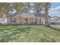 Charming brick home with an inviting front porch, classic shutters, and a well-manicured lawn at 886 Piccadilly Cir, Charleston, SC 29412