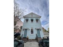 Charming two-story house with a light blue facade, white trim, and matching blue doors and awnings at 101 Queen St, Charleston, SC 29401