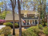 Charming brick home with a welcoming front porch, American flag, and beautiful mature landscaping at 109 Buckingham Ave, Summerville, SC 29485