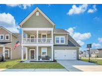 Charming two-story home featuring a welcoming front porch, attached garage, and well-manicured lawn at 131 Swaying Palm Dr, Summerville, SC 29485