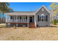 Charming one-story home featuring a welcoming front porch and light-gray siding at 146 Picard Dr, Ladson, SC 29456