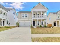 Charming two-story home featuring a welcoming front porch and a well-manicured lawn at 187 Red Blf St, Summerville, SC 29483