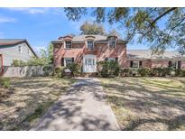 Charming two-story brick home with dormer windows, white trim and a mature landscaped front yard at 30 Hunters Forest Dr, Charleston, SC 29414