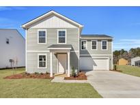 Charming two-story home with gray siding, white trim, manicured lawn, and attached two-car garage at 4171 Rising Tide Dr, Summerville, SC 29485