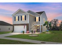 Charming two-story home with manicured lawn, stone accents, and a welcoming front entrance, perfect for a growing Gathering at 436 Blue Elderberry, Moncks Corner, SC 29461