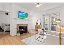 Cozy living room featuring a fireplace, ceiling fan, and access to the balcony at 45 Sycamore Ave # 626, Charleston, SC 29407