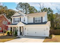 Charming two-story home featuring a well-maintained lawn, attached garage and a classic color palette at 467 Nelliefield Trl, Wando, SC 29492