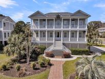 Stately two-story home with double porches and lush landscaping creating an inviting facade at 4922 Sound View Dr, Mount Pleasant, SC 29466