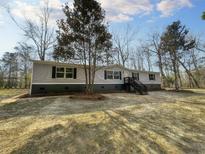 Charming home featuring gray siding, black shutters and trim, and wooden stairs at 532 Finlay Ln, Cottageville, SC 29435