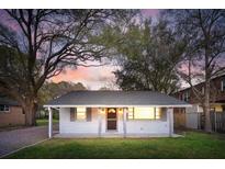 Charming single story home featuring a white brick facade and lush, mature landscaping at 706 White Oak Dr, Charleston, SC 29407