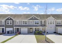 Charming townhouse with a two-car garage, complemented by a well-maintained front yard on a sunny day at 9712 Transplanter Cir, Ladson, SC 29456