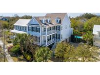 Charming two-story home with double porches, dark shutters, and lush surrounding trees at 1427 Wando View St, Daniel Island, SC 29492