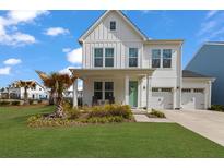 Charming two-story home features a manicured lawn, two-car garage, and a welcoming front porch at 1530 Homecoming Blvd, Ravenel, SC 29470