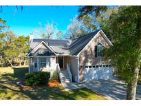 Charming home with solar panels, a two-car garage, and manicured landscaping, offering energy efficiency and curb appeal at 1810 Laura Creek Rd, Charleston, SC 29412