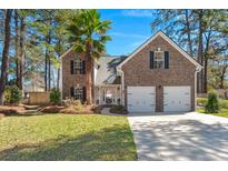 Charming two-story brick home with a well-manicured lawn, a two-car garage, and a lovely palm tree at 188 Bamert St, Summerville, SC 29483