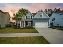 Charming two-story home with a well-manicured lawn, palm trees, and a two-car garage at 306 Long Pier St, Summerville, SC 29486