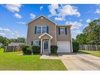 Charming two-story home featuring blue shutters, a well-manicured lawn, and an attached garage on a sunny day at 309 Taggert Cir, Goose Creek, SC 29445