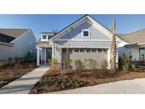 Charming light blue home featuring an attached garage and a beautifully landscaped front yard at 332 Dahlia Row Dr, Summerville, SC 29486