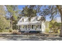 Charming two-story home with a welcoming front porch and mature trees in Historic Summerville, SC at 401 S Magnolia St, Summerville, SC 29483