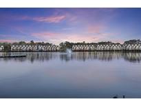 Waterfront condos view featuring a fountain at sunset with balconies and private boat dock at 4789 Arco Ln, North Charleston, SC 29418
