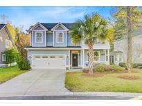 Charming two-story home with a light blue facade, manicured lawn, and mature palm tree at 5415 Clairmont Ln, North Charleston, SC 29420