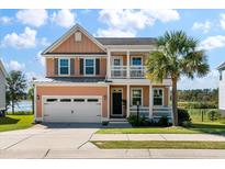 Charming two-story home with a manicured lawn and a welcoming front porch with a palm tree at 543 Pendleton Dr, Moncks Corner, SC 29461