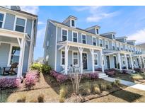 Charming two-story home with a welcoming front porch and beautiful landscaping at 565 Blueway Ave, Summerville, SC 29486