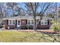 Charming brick home featuring a well-maintained lawn, classic design, and a welcoming entrance with detailed door accents at 5921 Oak St, Hanahan, SC 29410