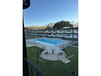 An aerial view of a pool with lounge area, surrounded by well-maintained green spaces and a charming building at 6601 Dorchester Rd # 109, North Charleston, SC 29418