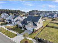 Beautiful two-story home with well-manicured lawn and backyard facing a tranquil pond and a mature tree line at 219 Daybreak Blvd, Summerville, SC 29486