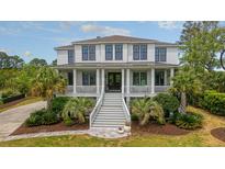 Stunning two-story home with inviting porch, well-manicured lawn, and lush landscaping at 4874 Sound View Dr, Mount Pleasant, SC 29466