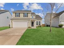 Charming two-story home featuring a well-manicured lawn and attached two-car garage at 529 Pleasant Side Dr, Moncks Corner, SC 29461