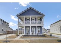 Charming two-story home with a double porch, blue siding, and nicely landscaped yard at 69 Arrowwood Way, Summerville, SC 29485