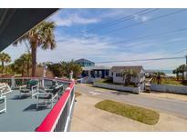 Charming deck with comfortable seating and scenic views of the neighborhood and ocean at 716 E Arctic Ave, Folly Beach, SC 29439