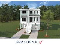 Charming two-story coastal home with a well-manicured lawn and ample greenery and a staircase to the front door at 718 Minton Rd, Charleston, SC 29412