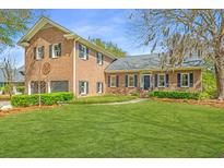 Charming brick home with a manicured front yard, mature trees and professional landscaping at 750 Lakenheath Dr, Mount Pleasant, SC 29464