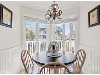Bright breakfast nook with a decorative chandelier and a bay window overlooking the outdoor area at 9000 Palmetto Dr # G203, Isle of Palms, SC 29451