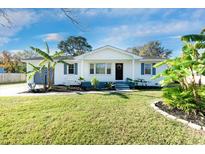 Charming white bungalow with a well-manicured lawn and tropical landscaping at 1077 Harbor View Rd, Charleston, SC 29412