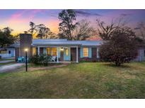 Charming brick home featuring a metal roof, inviting entry and well-maintained lawn with a lovely sunset backdrop at 112 Robin Ct, Summerville, SC 29485