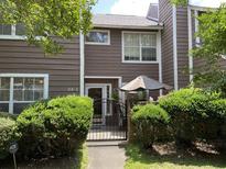 Charming townhome featuring brown siding, a gated front patio, and well-maintained landscaping at 114 Luden Dr # C, Summerville, SC 29483