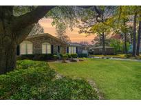 Charming brick home featuring lush landscaping, a well-manicured lawn, and mature trees, creating a welcoming curb appeal at 115 Clubhouse Rd, Summerville, SC 29483