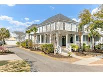 Charming two-story home featuring a spacious front porch and well-maintained landscaping with blue skies above at 1429 Lettered Olive Ln, Mount Pleasant, SC 29464