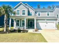 Charming two-story home with a well-manicured lawn, covered porch, and attached two-car garage at 150 Haverhill St, Summerville, SC 29486