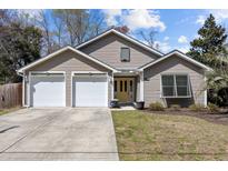 Charming single Gathering home with a yellow front door, two-car garage, and well-maintained lawn at 1617 Southwick Dr, Johns Island, SC 29455